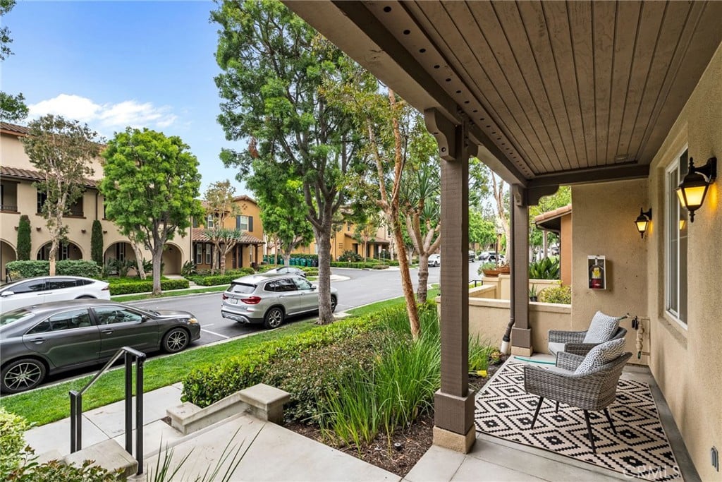 A covered front porch with a wood ceiling, looking out over a landscaped street